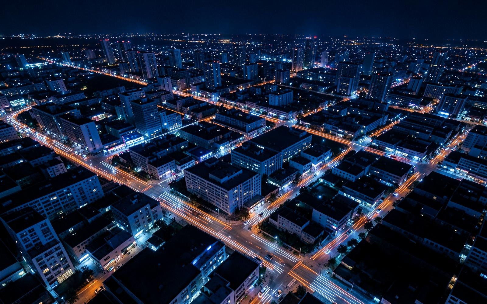 Illuminated city infrastructure viewed from above at night